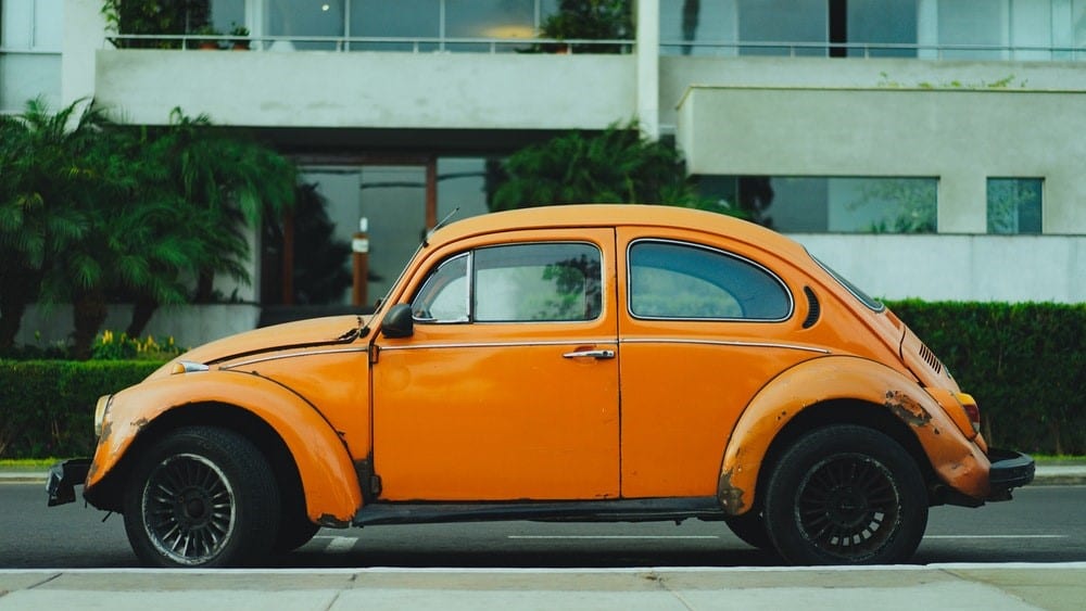 An orange car by the side of the road