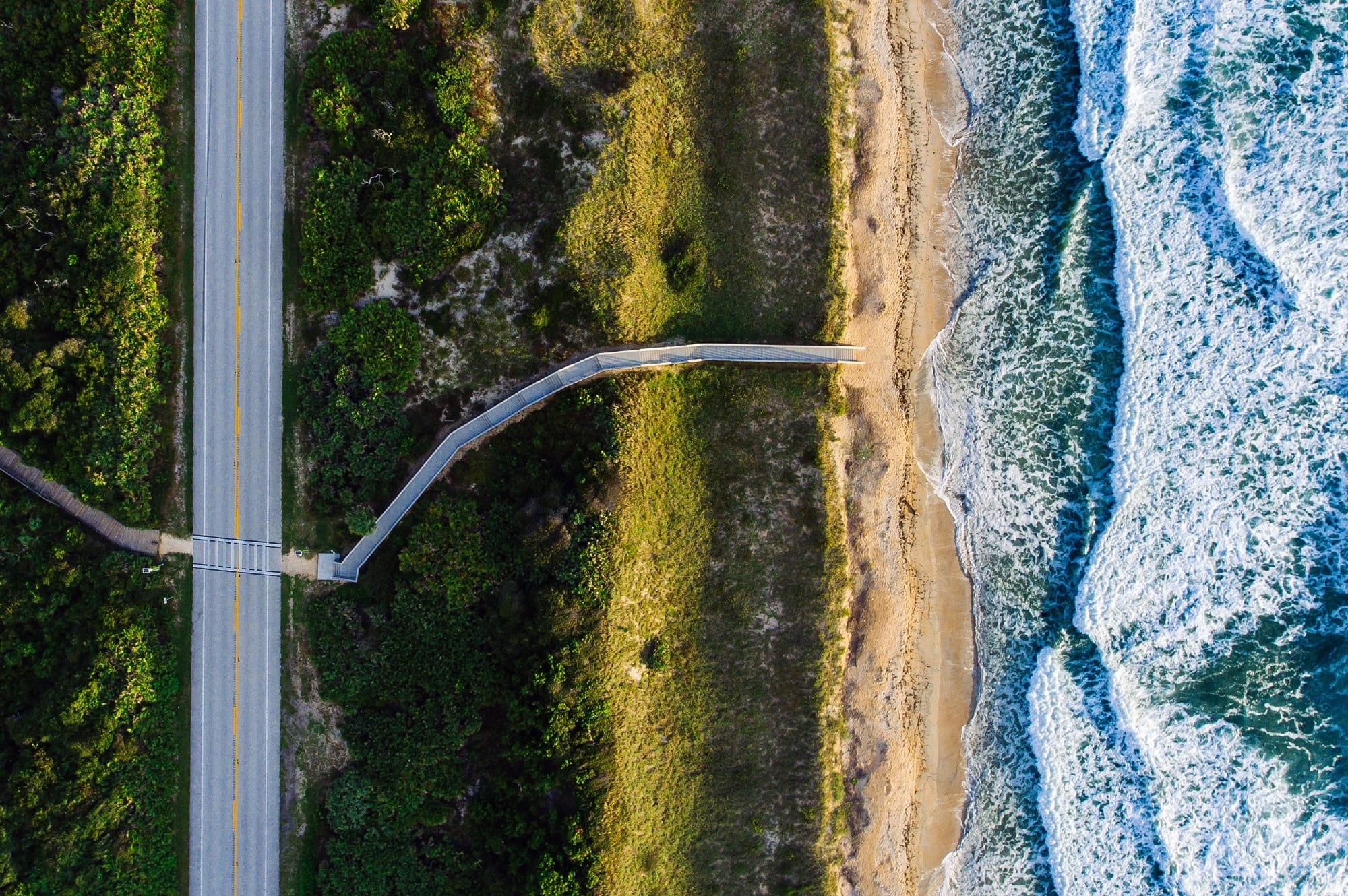 A road, the grass and the sea aerial view