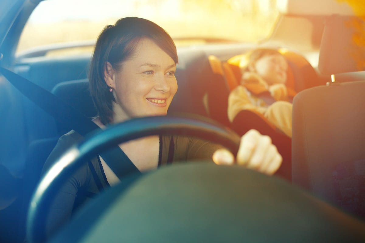 Woman driving with small child in the back