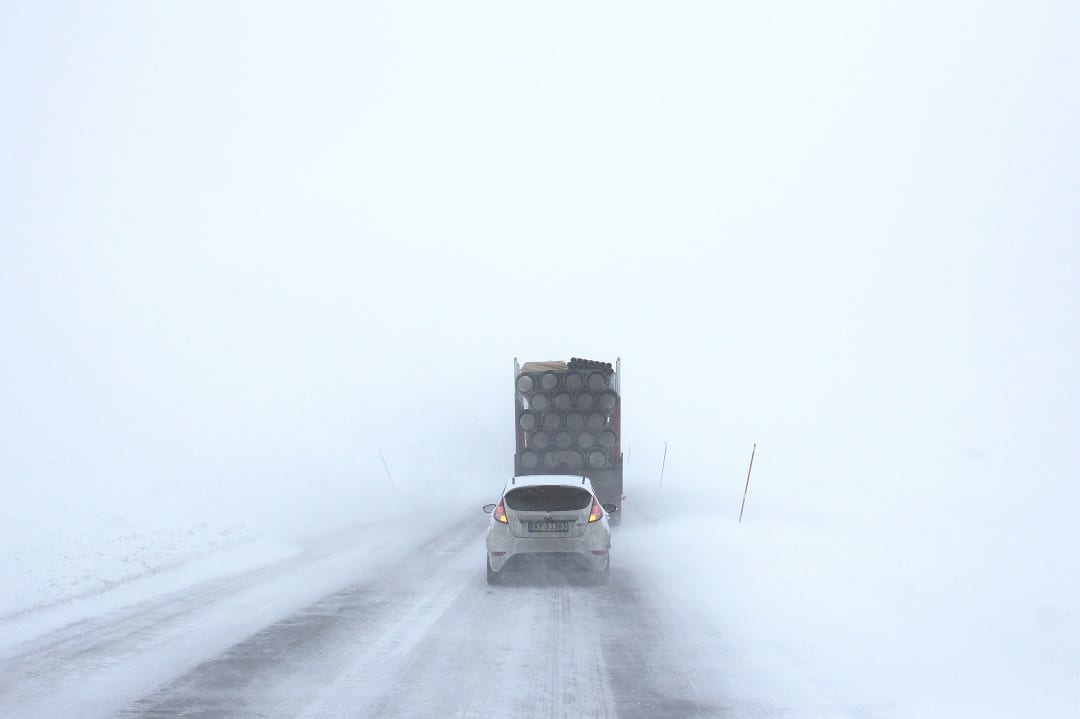 Snow on the road with a car and a lorry