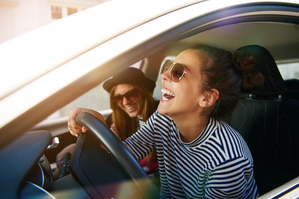 woman driving in car with friends