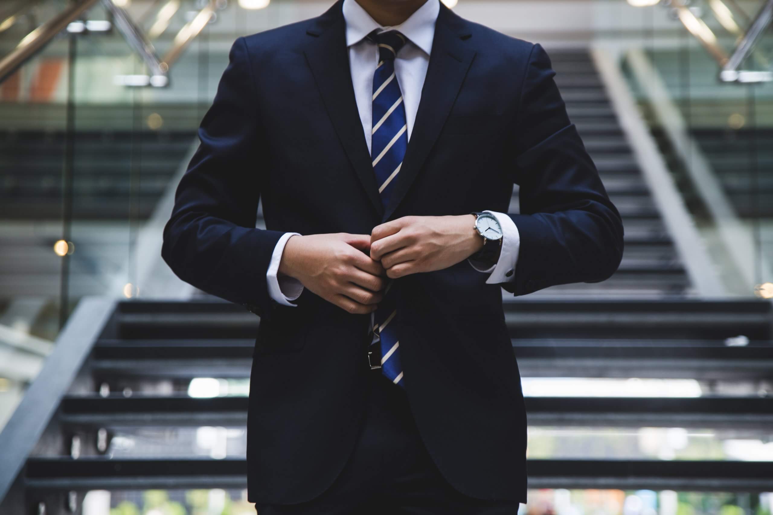 Buisness man doing up suit jacket