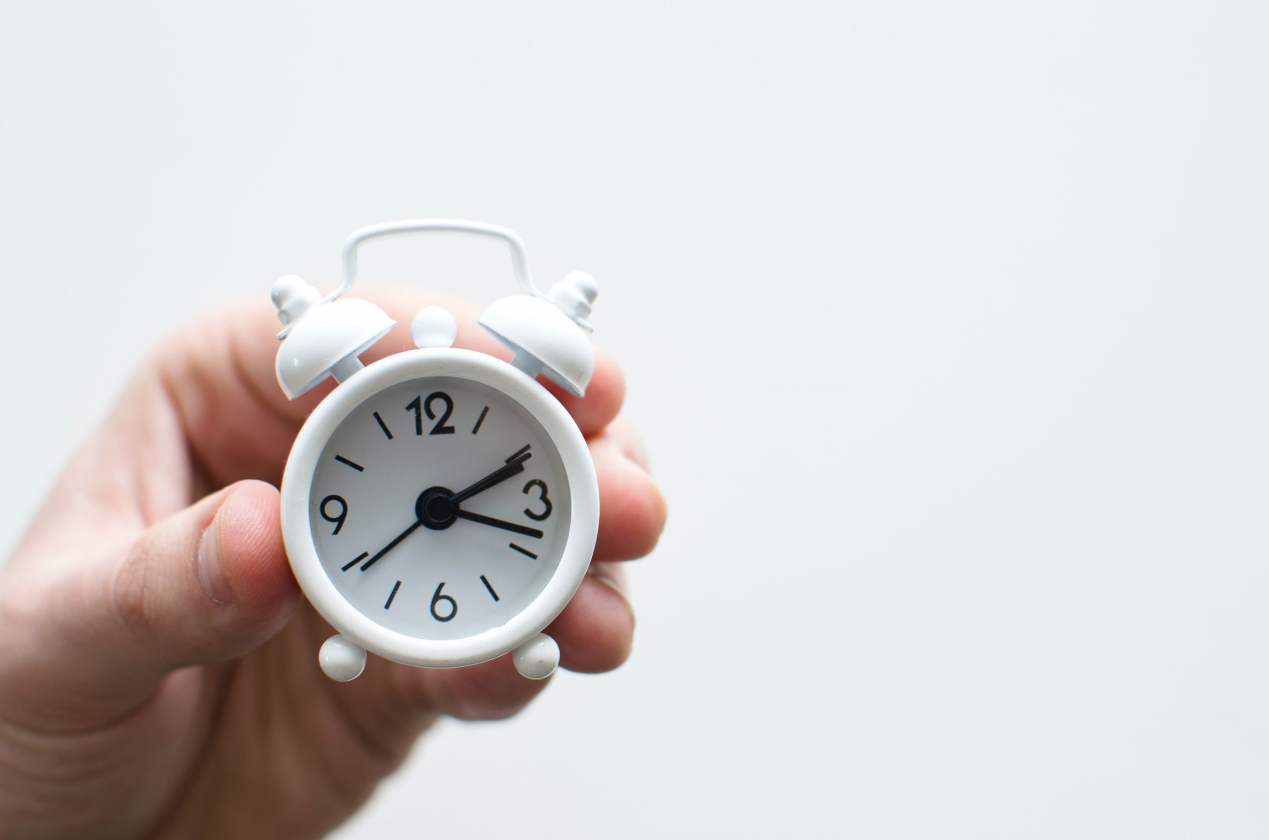 Hand holding small clock