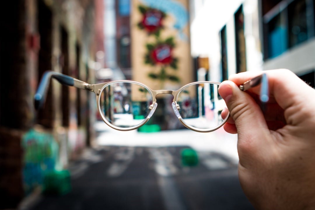 A person holding up their glasses