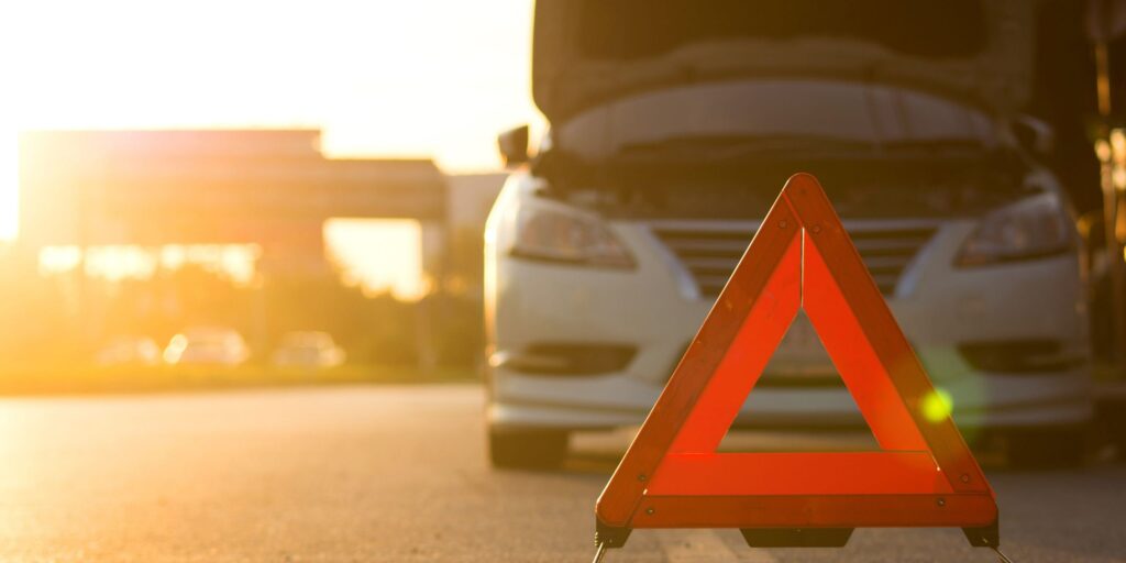 Broken down car with triangle infront