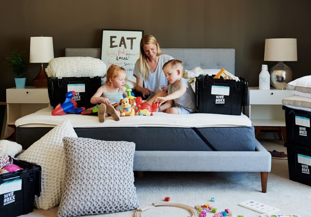 Young mother and children unpacking boxes
