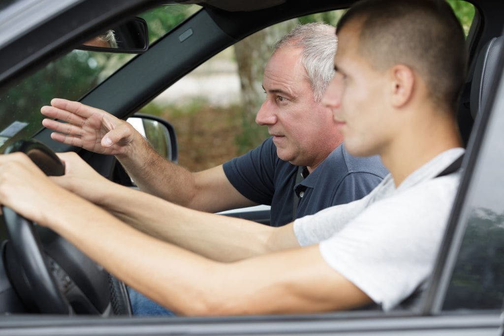 Father teaching his son how to drive